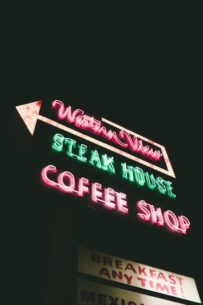 低角度摄影的西方观点牛排馆咖啡厅的霓虹灯标牌晚上打开
